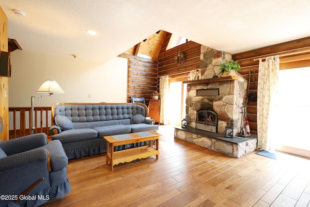living area with a textured ceiling, log walls, vaulted ceiling, a fireplace, and wood finished floors