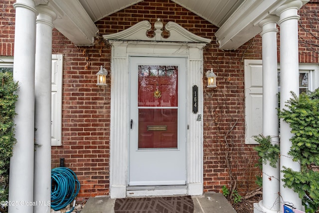 entrance to property featuring brick siding