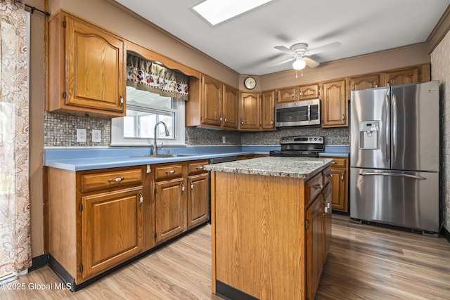 kitchen with a kitchen island, backsplash, brown cabinets, light wood finished floors, and stainless steel appliances