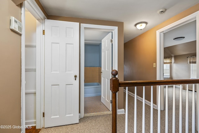corridor with light colored carpet and baseboards