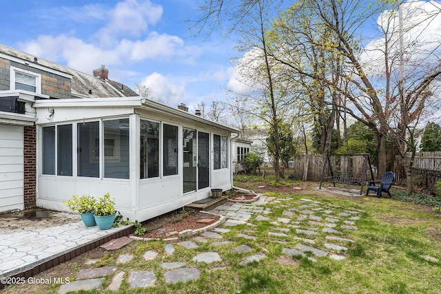 view of yard featuring a sunroom and fence