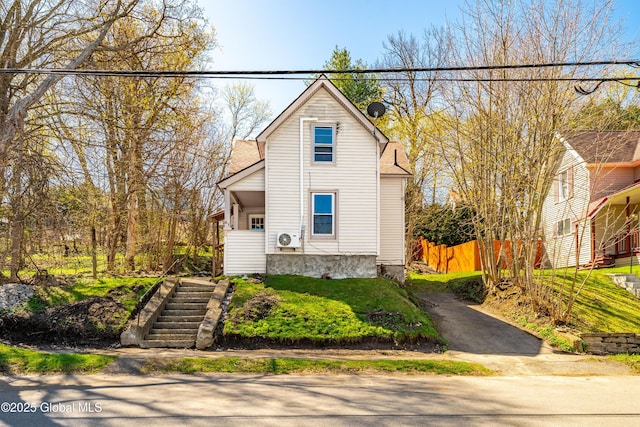 view of front of property featuring fence and stairway