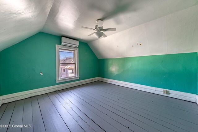 bonus room with ceiling fan, an AC wall unit, baseboards, lofted ceiling, and hardwood / wood-style flooring