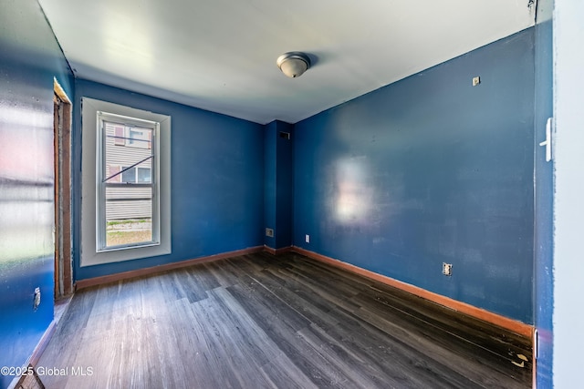 empty room featuring baseboards and wood finished floors