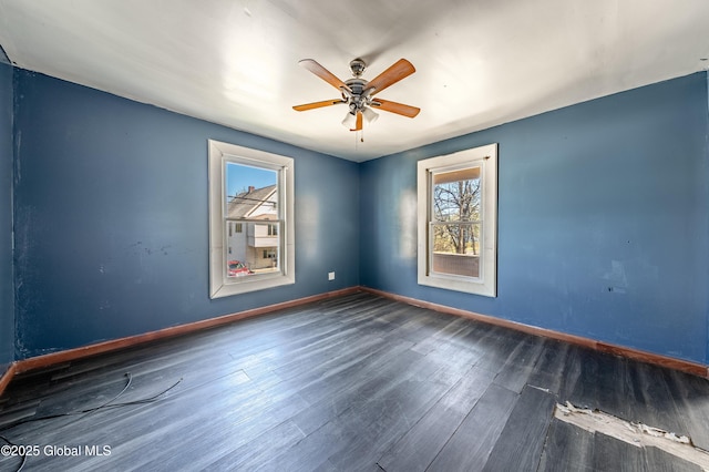 empty room featuring baseboards, ceiling fan, and wood finished floors