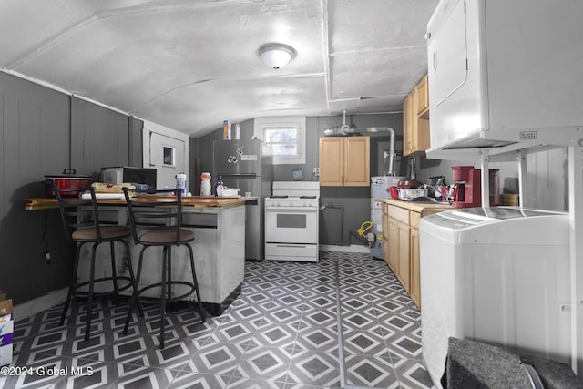 kitchen with washer / clothes dryer, light floors, lofted ceiling, and white gas range