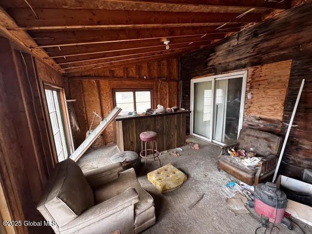 misc room featuring wood walls and vaulted ceiling