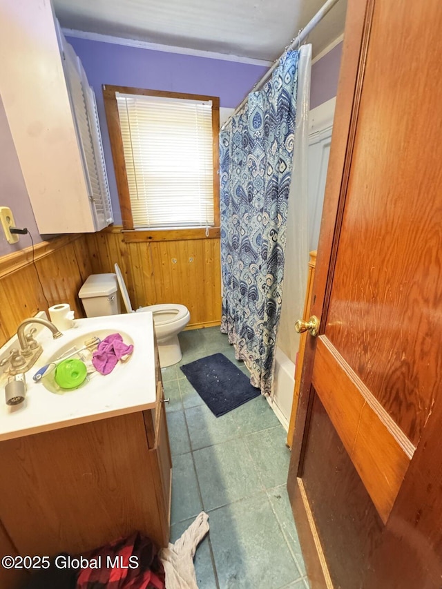 full bathroom with wainscoting, wood walls, vanity, and toilet