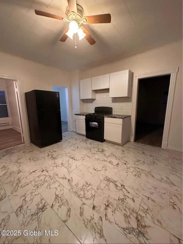 28 Pulaski St, Amsterdam, NY 12010 - kitchen with dark countertops, a baseboard heating unit, white cabinets, a ceiling fan, and black appliances