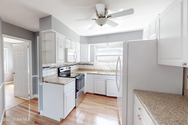 kitchen with light wood-type flooring, a sink, light countertops, white cabinets, and white appliances