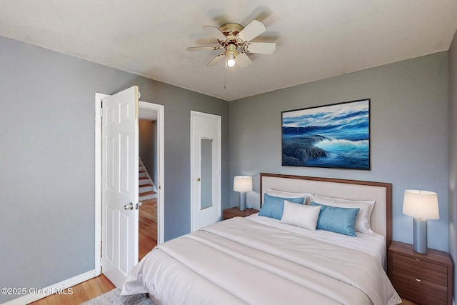 bedroom with baseboards, a ceiling fan, and wood finished floors