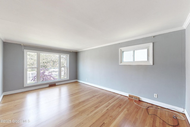 spare room with crown molding, baseboards, and visible vents