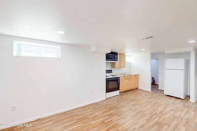 kitchen featuring range with electric cooktop, visible vents, black microwave, light countertops, and freestanding refrigerator