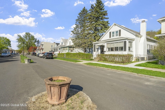 view of road with a residential view, sidewalks, and curbs