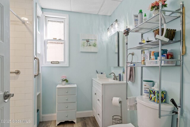 full bath with toilet, walk in shower, wood finished floors, and vanity