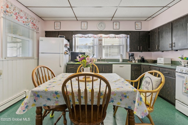 kitchen featuring a sink, baseboard heating, white appliances, and a paneled ceiling