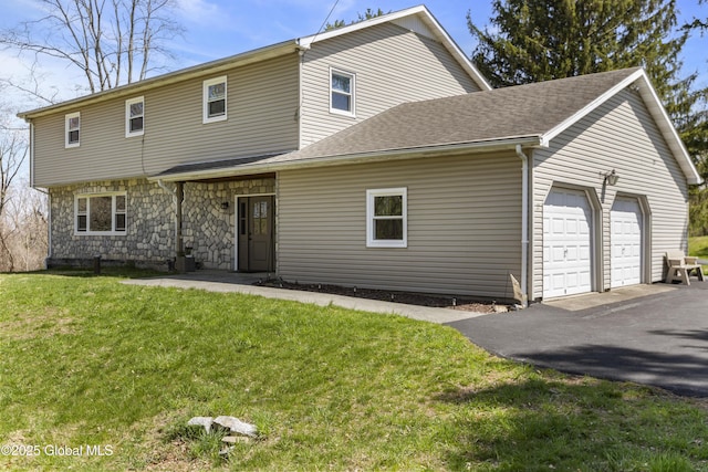view of front facade with a garage, aphalt driveway, and a front lawn