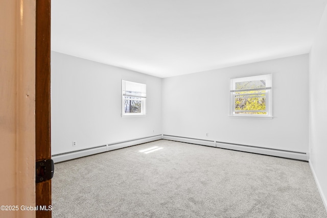 unfurnished room with carpet floors, a baseboard radiator, baseboards, and a wealth of natural light