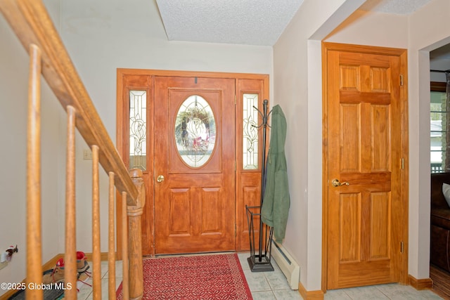 entryway with baseboards, a textured ceiling, light tile patterned floors, and baseboard heating