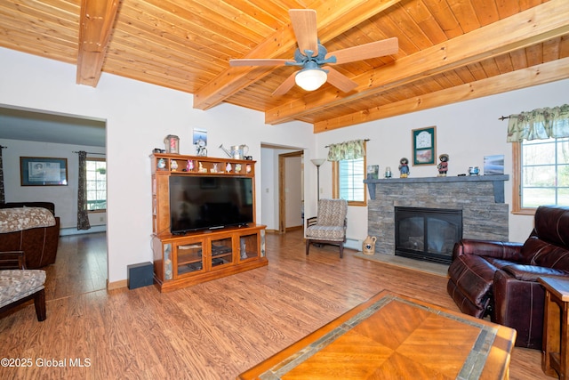 living area with beam ceiling, a fireplace, a ceiling fan, wood finished floors, and wood ceiling