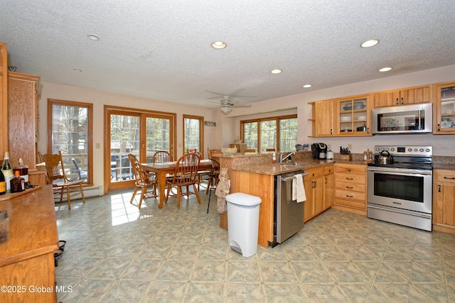 kitchen featuring stainless steel appliances, a textured ceiling, and a sink