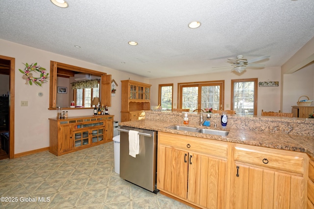 kitchen with stainless steel dishwasher, a sink, a textured ceiling, and a ceiling fan