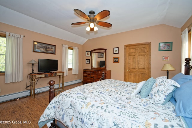 bedroom featuring multiple windows, baseboard heating, lofted ceiling, and wood finished floors