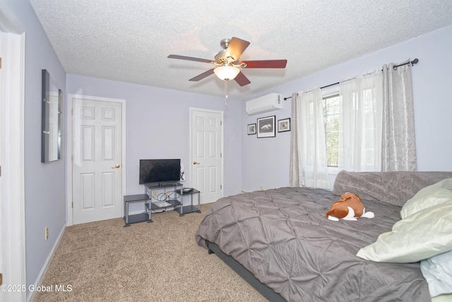 carpeted bedroom with a textured ceiling, baseboards, a ceiling fan, and a wall mounted air conditioner