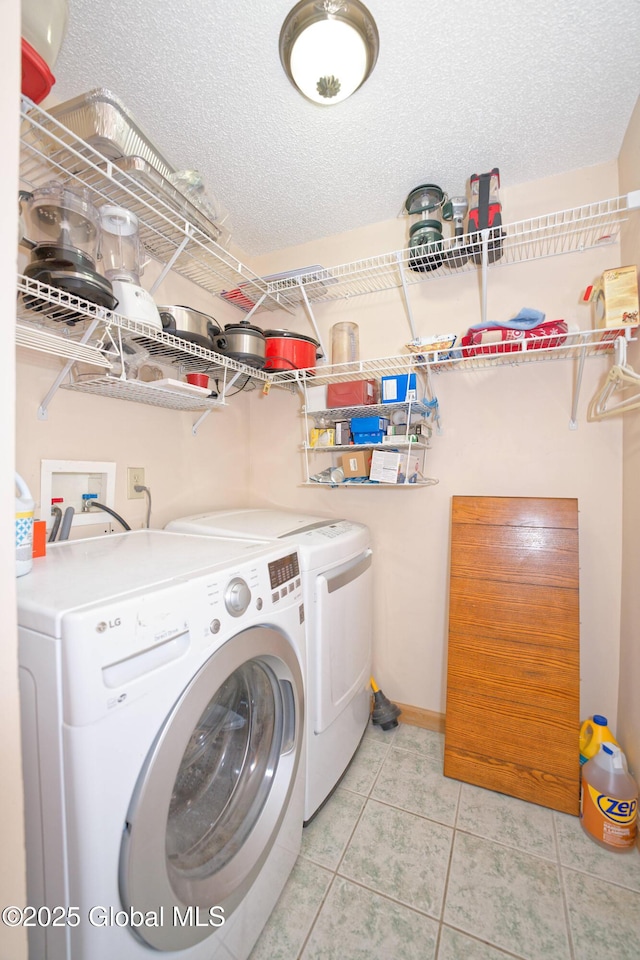 laundry area with laundry area, light tile patterned floors, and washing machine and clothes dryer