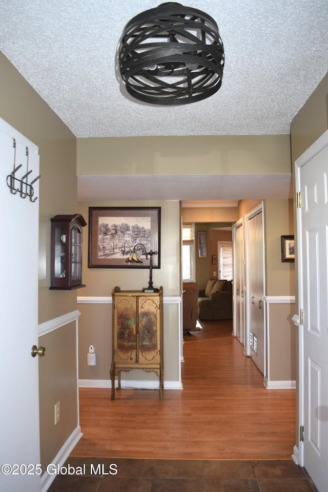 hallway featuring baseboards and wood finished floors