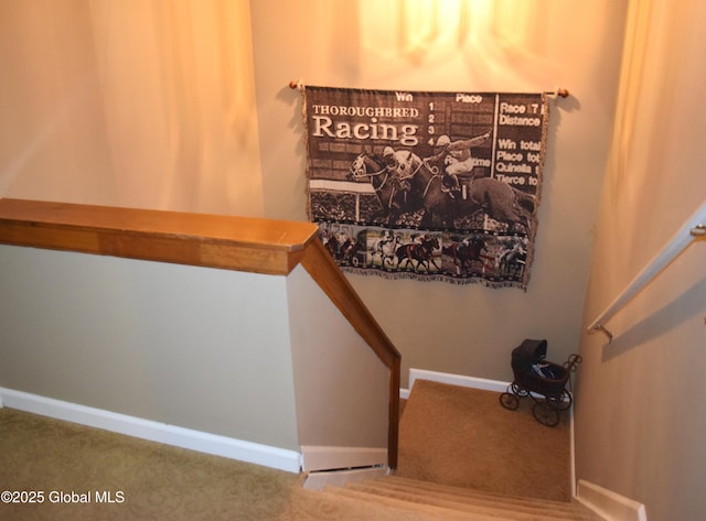 staircase featuring carpet floors and baseboards