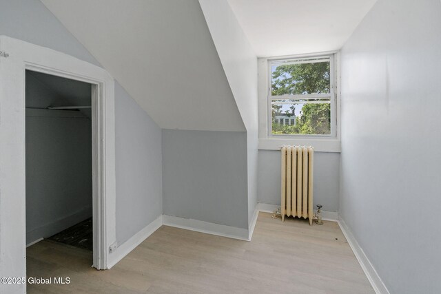 502 1st St, Albany, NY 12206 - additional living space featuring radiator, light wood finished floors, vaulted ceiling, and baseboards
