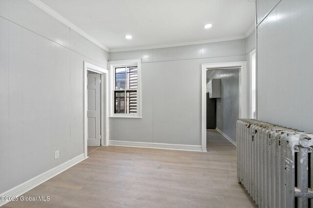 502 1st St, Albany, NY 12206 - hall with radiator heating unit, light wood finished floors, crown molding, baseboards, and recessed lighting