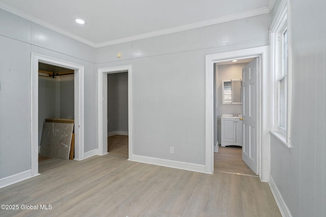 502 1st St, Albany, NY 12206 - unfurnished bedroom featuring light wood-type flooring, baseboards, a spacious closet, and crown molding