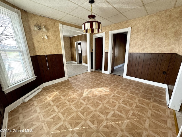 29 Park St, Fonda, NY 12068 - empty room featuring wood walls, a paneled ceiling, and wainscoting