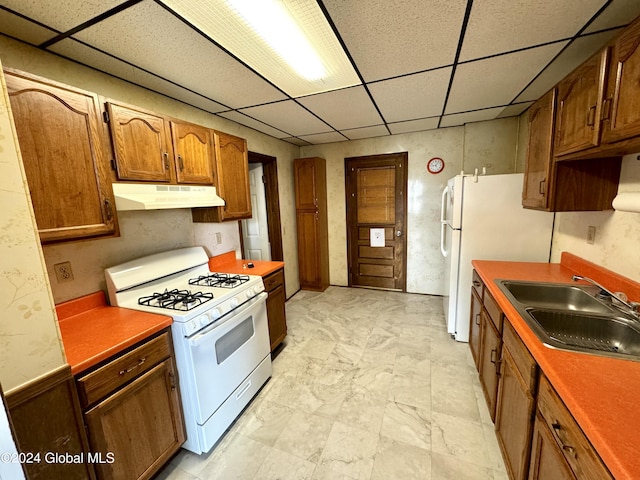 29 Park St, Fonda, NY 12068 - kitchen featuring brown cabinets, a sink, white appliances, a paneled ceiling, and under cabinet range hood