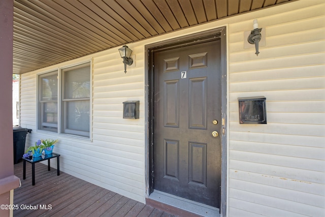 view of exterior entry featuring covered porch