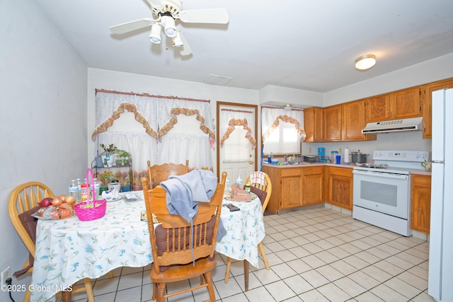 kitchen with a ceiling fan, light countertops, light tile patterned floors, under cabinet range hood, and white appliances