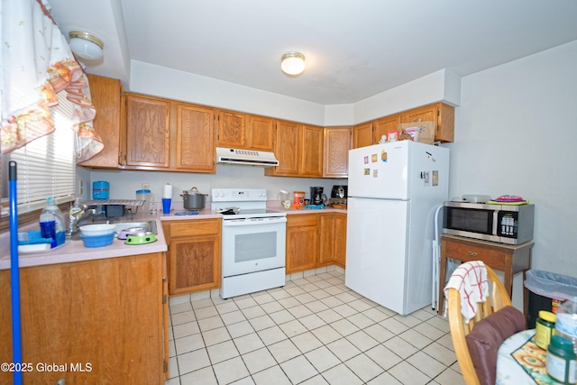 kitchen featuring white appliances, light countertops, under cabinet range hood, a sink, and light tile patterned floors