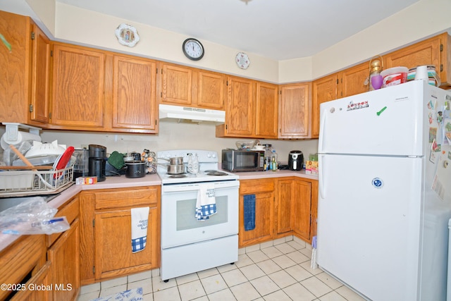 kitchen featuring white appliances, light tile patterned flooring, under cabinet range hood, and light countertops