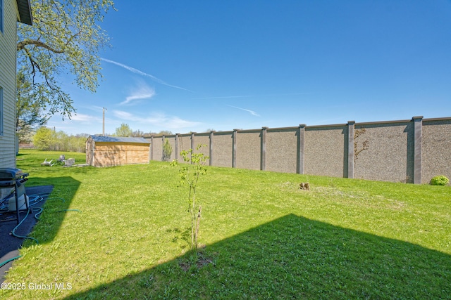 view of yard featuring fence, an outdoor structure, and a storage shed