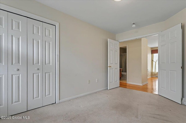 unfurnished bedroom featuring carpet floors, baseboards, and a closet