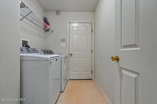 washroom with baseboards, separate washer and dryer, laundry area, and light tile patterned flooring