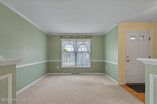 carpeted empty room with crown molding, baseboards, and visible vents