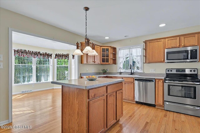 kitchen featuring a kitchen island, open shelves, stainless steel appliances, and light wood-type flooring