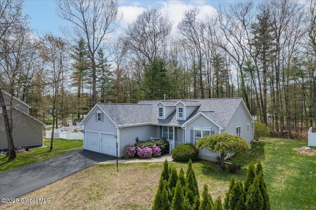view of front of house featuring a garage, a shingled roof, a front yard, and aphalt driveway