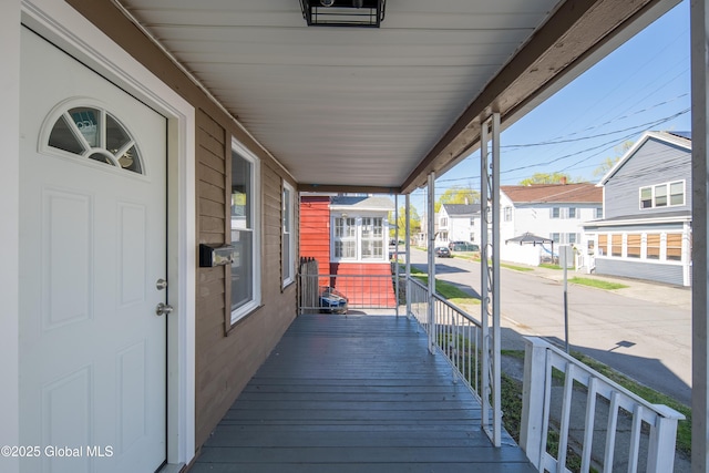 wooden terrace featuring covered porch and a residential view