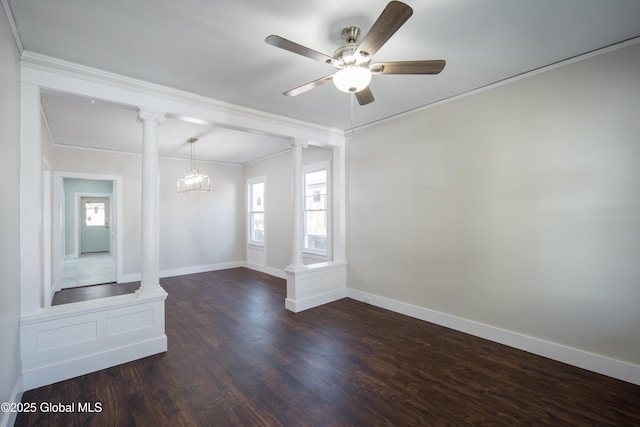 spare room with ornate columns, ornamental molding, dark wood finished floors, and ceiling fan with notable chandelier