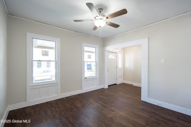 foyer entrance featuring ceiling fan, visible vents, crown molding, baseboards, and dark wood-type flooring