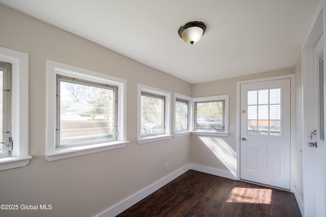 entryway featuring baseboards and dark wood-type flooring